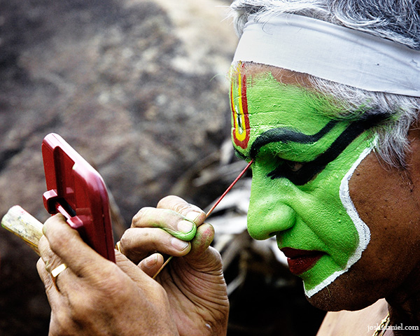 Portrait of Ottam Thullal artist Kalamandalam Prabhakaran doing make-up