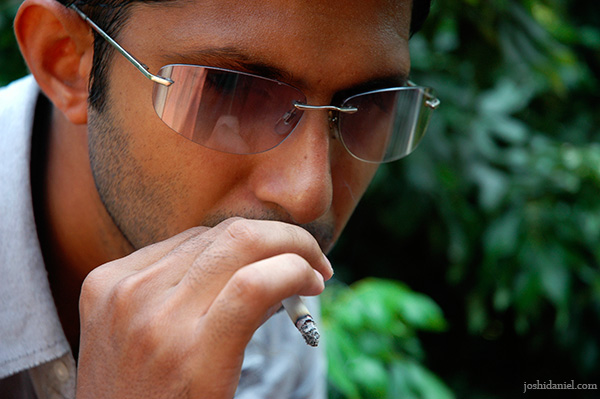 Outdoor portrait of male model Siddharth Reghunath smoking a cigarette