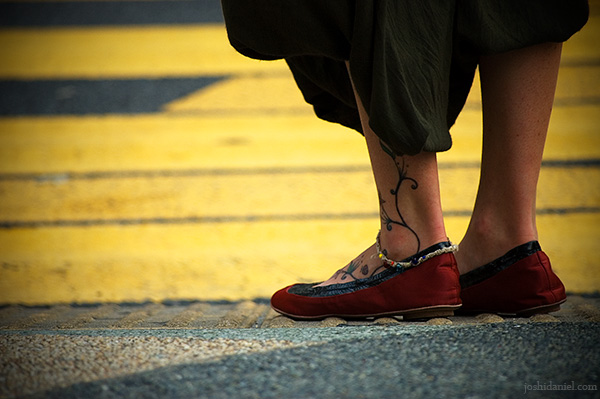 Tattooed leg" alt="Girl with tattooed leg waiting to cross the road in Bukit Bintang, Kuala Lumpur, Malaysia