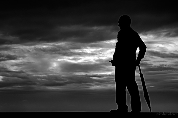 Silhouette of a man with umbrella Silhouette of a man with umbrella on a cloudy day at Marine Drive, Mumbai, India