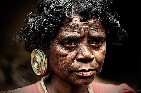 Portrait of a paniya woman with a large ear plug from Wayanad