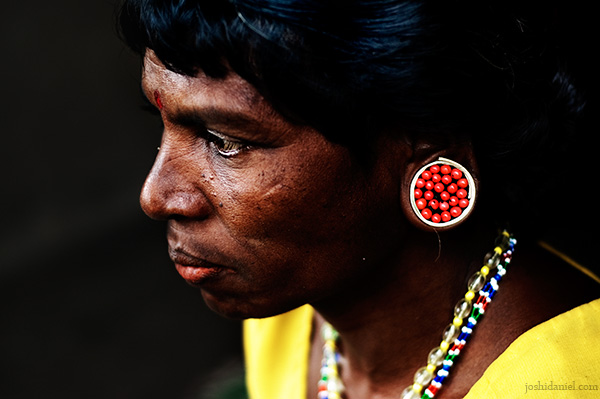 Portrait of a paniya woman with ear plug made of manjadikkuru (circassian seed)