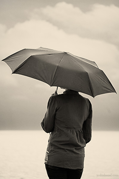 A girl with an umbrella waiting in silence in Shankhumugham beach, Trivandrum