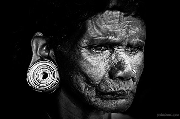 Black and white portrait of a tribal woman with a large ear plug from Wayanad in Kerala