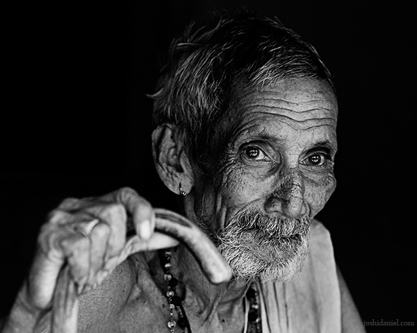 Black and white portrait of an old man from Karnataka holding a walking stick
