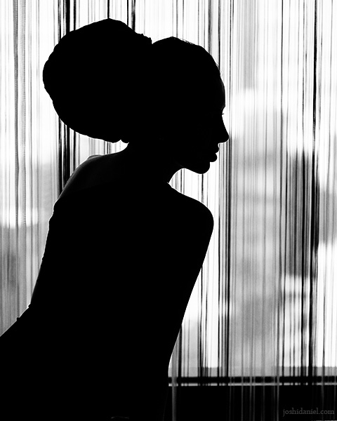 Silhouette of a girl sitting near a window
