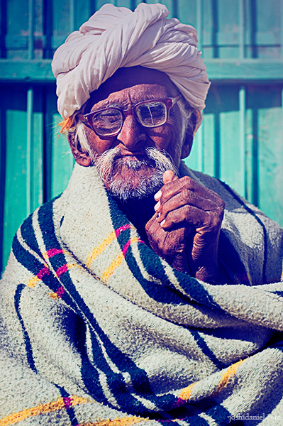 Portrait of an old bespectacled man in a turban wrapped in warm clothing from Rajasthan