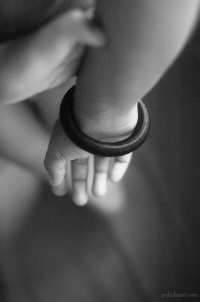 Black and white photograph of a girl's hands behind her back