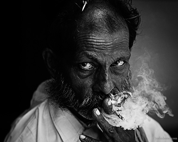 Black and white portrait of an intriguing man from Gokarna smoking