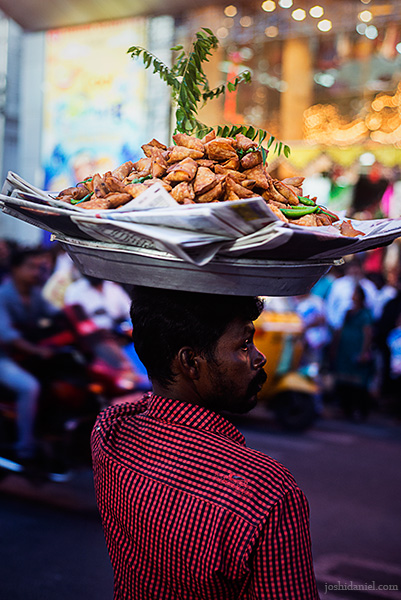 A samosa seller crossing the road in T. Nagar in Chennai