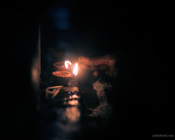 A woman lighting oil lamps during the Karthikai Deepam festival in Kapaleeshwarar Temple in Chennai