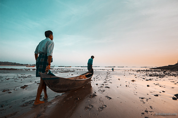 Fishermen in Murudeshwara, Karnataka carrying their boat into the sea after sunset