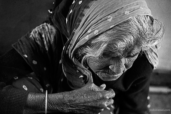 Black and white portrait of an old woman sitting inside a train in Haridwar