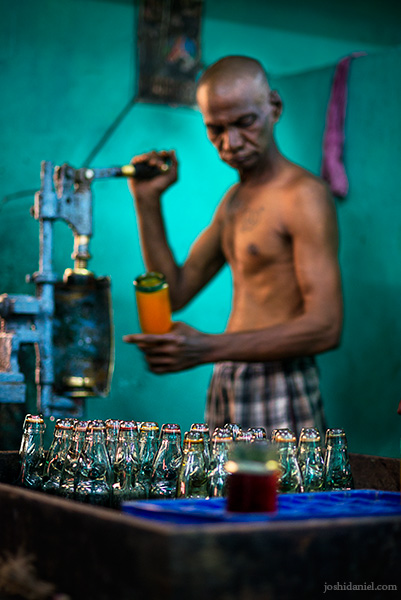 A worker at Vasu and Co. Goli soda factory in Chennai aerating the contents of a soda bottle