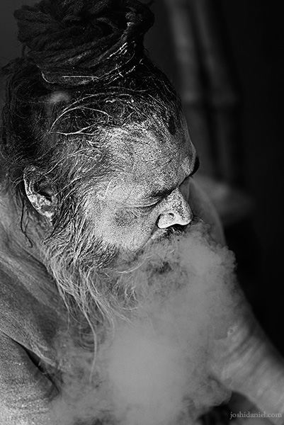Black and white portrait of a Naga sadhu smoking in Varanasi