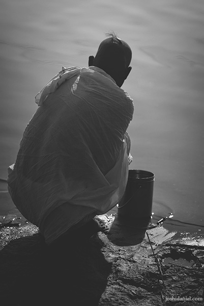 A pilgrim sitting by the river side at the Maha Kumbh Mela in Allahabad