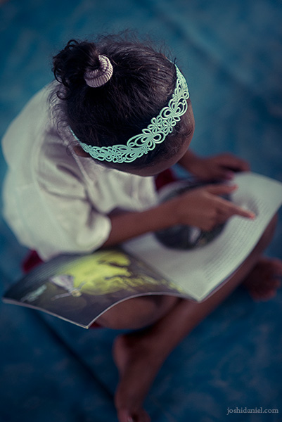 Little girl reading in Taman Bacaan Pelangi Little girl reading a story book in Taman Bacaan Pelangi (Rainbow Reading Gardens) in Melo Village in Flores, Indonesia