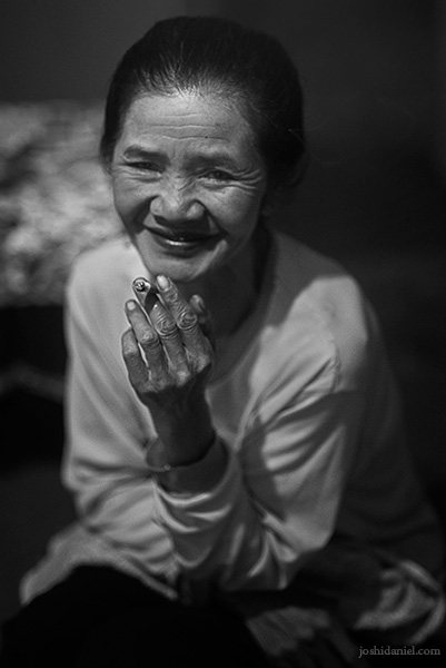 Black and white portrait of Marsiti holding a cigarette in her hand in Probolinggo, Java East, Indonesia