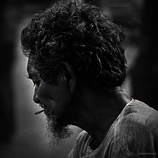 Black and white portrait of a banana vendor smoking in Grant Road, Mumbai