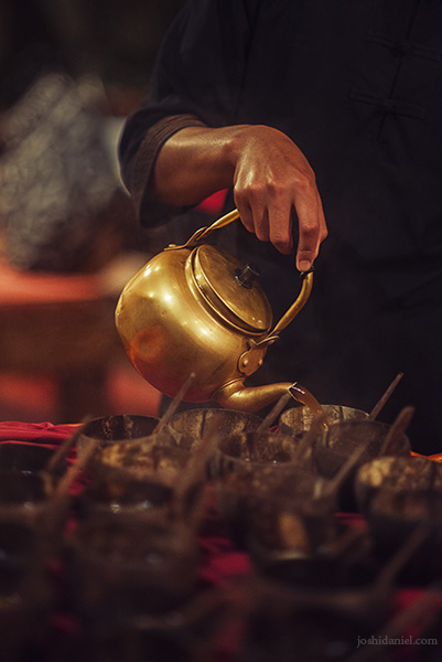 A man serving the Indonesian beverage bandrek into cups in Kampung Daun, Indonesia