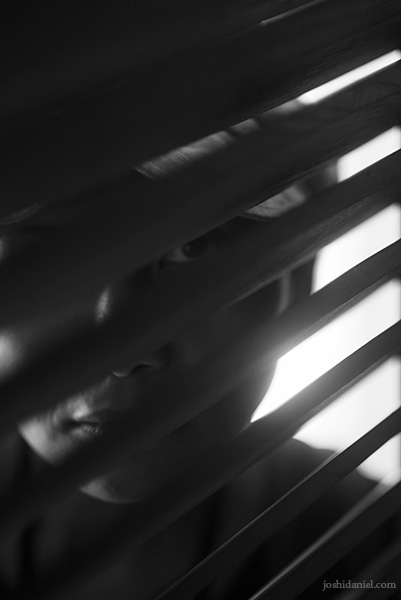 Black and white portrait of Windy Ariestanty staring through a window in Taman Sari, Yogyakarta