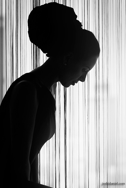 Black and white portrait of a girl sitting near a window