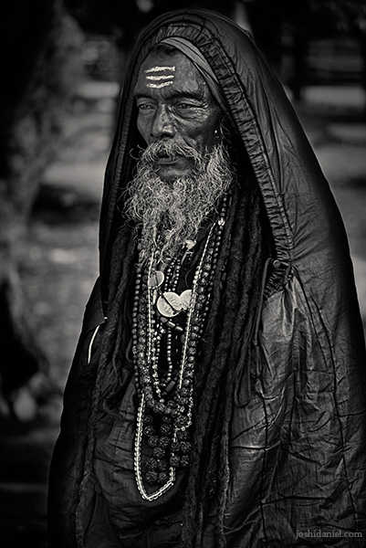 Black and white portrait of a man in a sleeping bag during Kumbh mela, Haridwar