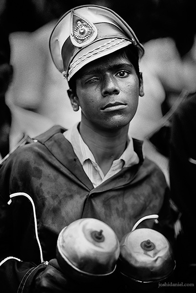 A black and white portrait of a young boy from a Chennai musical band holding a pair of maracas