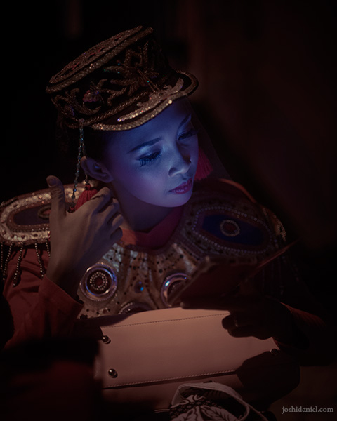 Portrait of a participant looking at her phone during a break in the Yogyakarta parade celebrating the 259th anniversary of the city