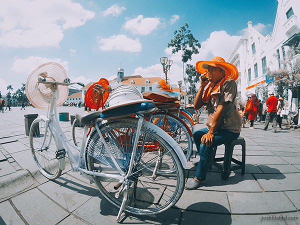 A young man who rents bicycles sipping coffee at Kota Tua area in Jakarta on the Indonesian Independence Day