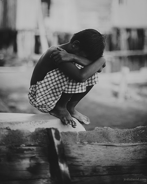Black and white photograph of a shy boy from Senggarang Village, Indonesia