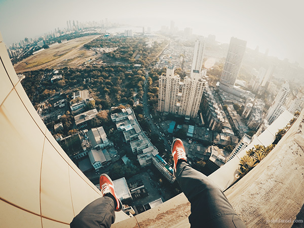 GoPro shot of joshi daniel's feet dangling above the cityscape of South Mumbai, Maharashtra, India