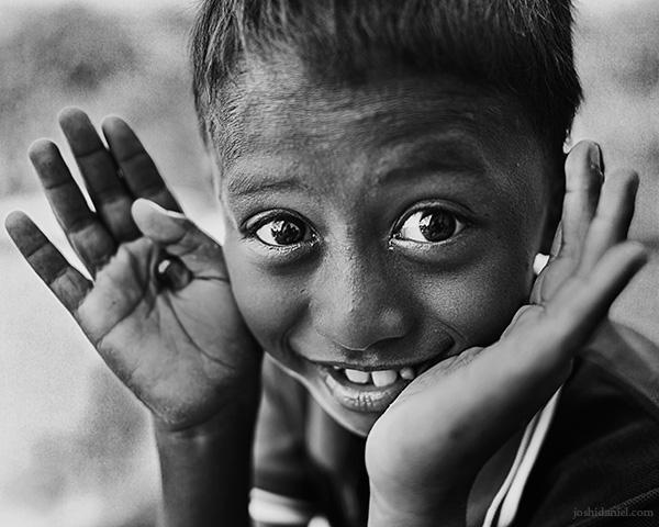 A 28mm wide angle black and white portrait of a smiling boy from Rainbow Village, Tual, Maluku, Indonesia