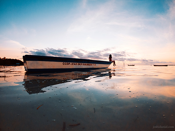 A girl sitting on a boat during sunset at Ngurbloat, Tual, Maluku, Kei Island, Indonesia