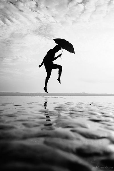 Abilash Thankan jumping with an umbrella at Azhimala beach in Trivandrum, Kerala, India