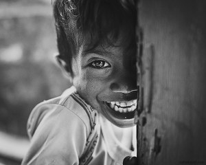 A 28mm wide angle black and white portrait of a laughing young boy from Rainbow Village, Tual, Maluku, Indonesia