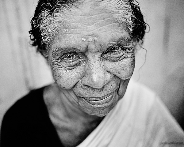 A 28mm wide angle black and white portrait of smiling old woman in Trivandrum, Kerala, India