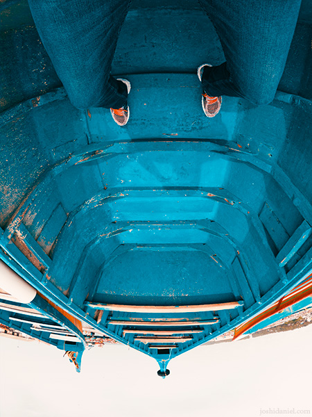 GoPro self-portrait of joshi daniel with his legs stretched out in a boat in Vizhinjam, Trivandrum, Kerala, India