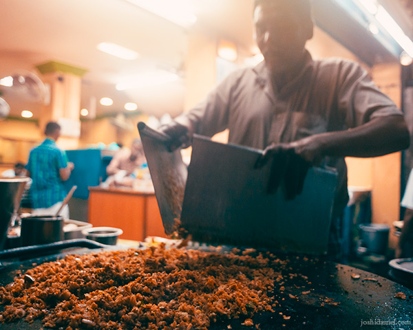 Portrait of a man in the process of making kothu parotta in Madurai, Tamil Nadu, India