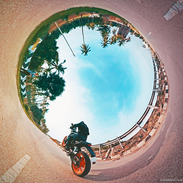Inverted little planet (tiny planet) self-portrait of joshi daniel pulling a wheelie on KTM Duke in Bangalore Rural, Karnataka, India