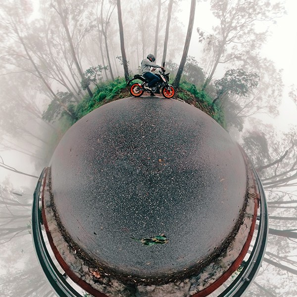 Little planet (tiny planet) self-portrait of joshi daniel on a KTM Duke in Nandi hills, Karnataka, India on a foggy day